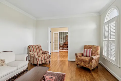 a dining room with furniture a chandelier and wooden floor