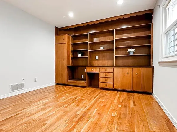 a view of empty room with wooden floor and cabinet