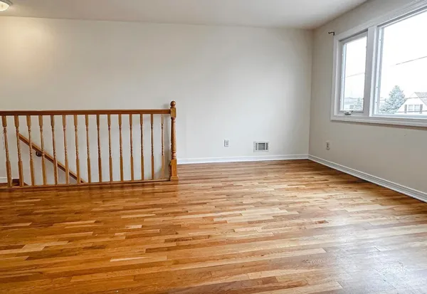 a view of a room with wooden floor and windows