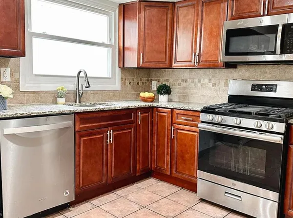 a kitchen with granite countertop a stove and a sink