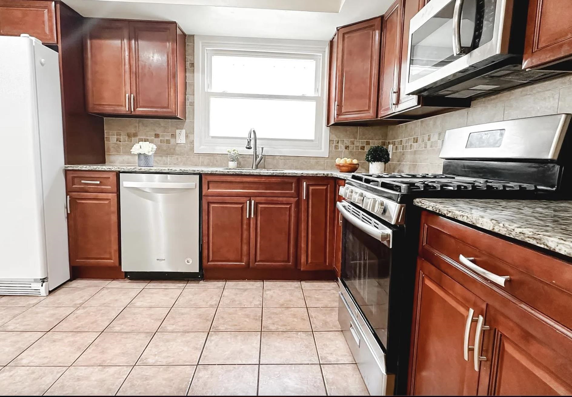 14 Centre Lane, Unit 2 Bayonne, NJ 07002 - Photo 9 of 21 a kitchen with stainless steel appliances granite countertop a stove a sink and a microwave