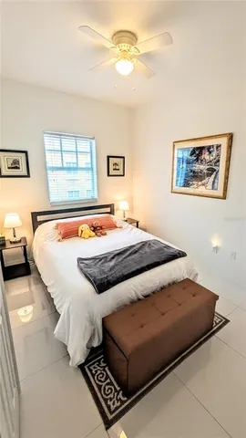 a bedroom with a bed and a refrigerator