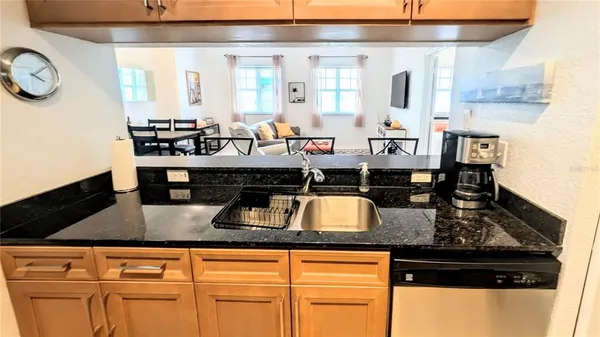 a kitchen with a stove and a view of living room