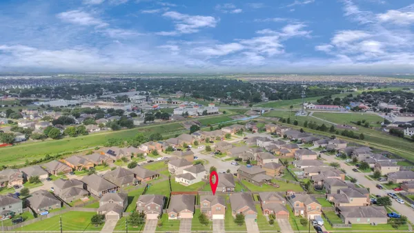 an aerial view of house with yard and mountain view in back