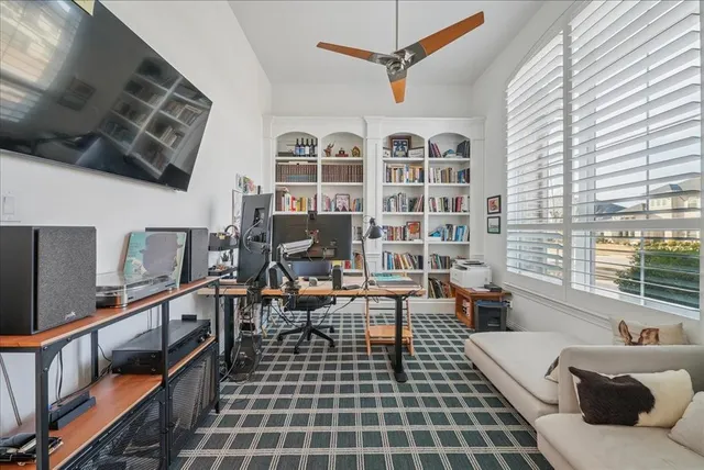 a living room with furniture a flat screen tv and a window