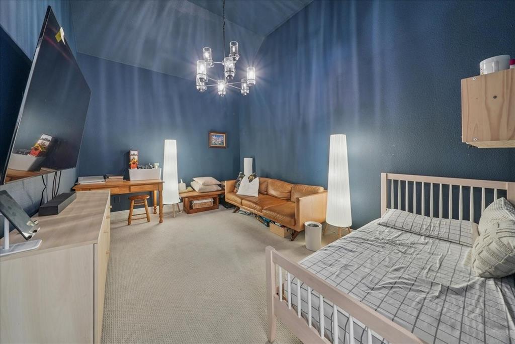 1981 Star Trace Parkway Prosper, TX 75078 - Photo 24 of 32 a bedroom with furniture and a chandelier