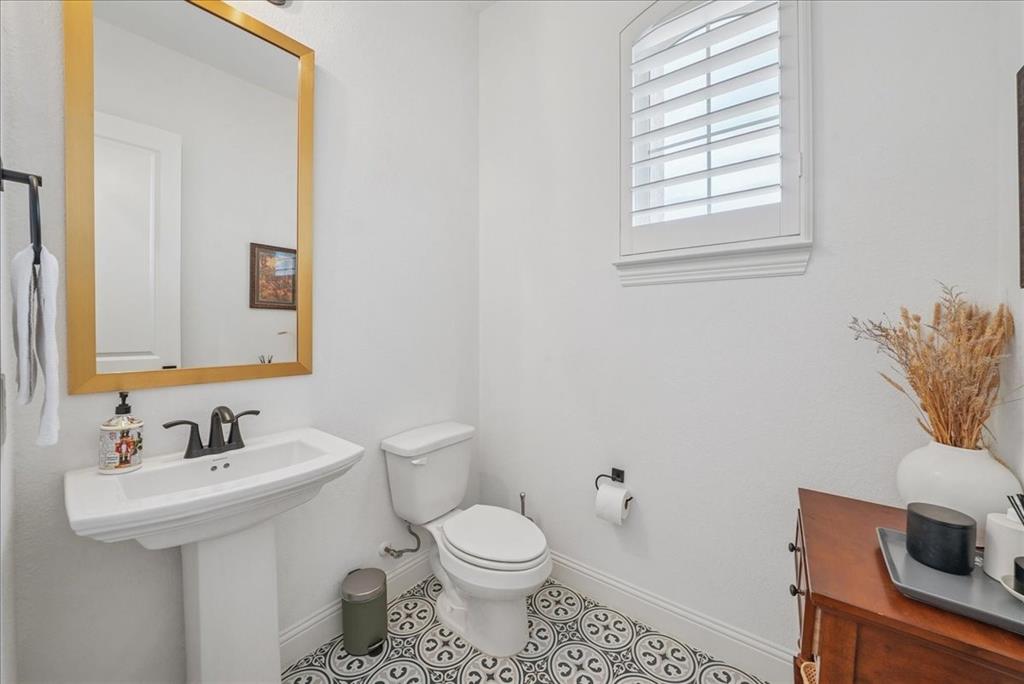 1981 Star Trace Parkway Prosper, TX 75078 - Photo 27 of 32 a bathroom with a toilet sink and mirror