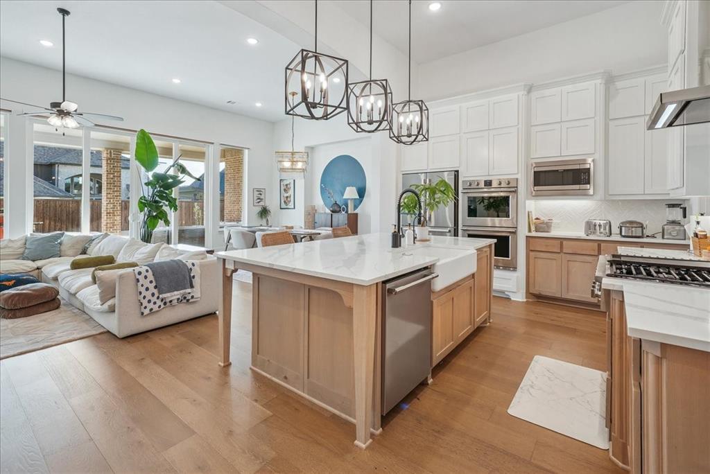 1981 Star Trace Parkway Prosper, TX 75078 - Photo 8 of 32 a large white kitchen with a large island oven a stove and a chandelier