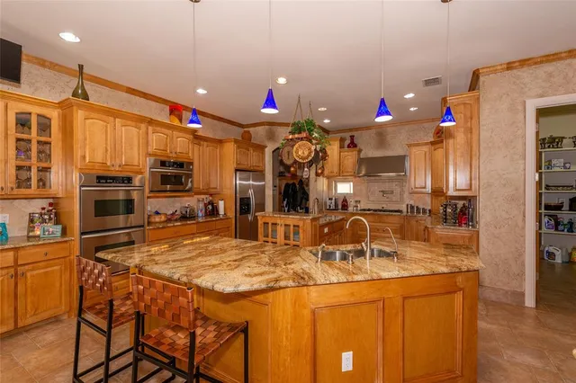 a kitchen area with granite countertop a sink cabinets and stainless steel appliances