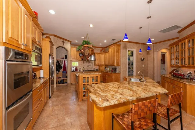 a kitchen island with stainless steel appliances kitchen island granite countertop a stove a sink a refrigerator and a dining table