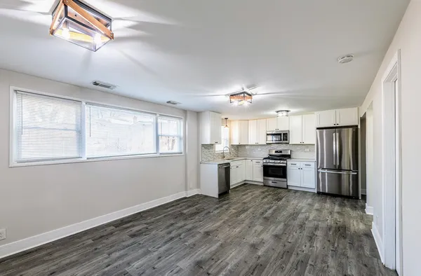 a kitchen with refrigerator cabinets and wooden floor
