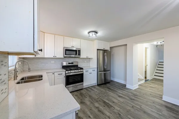 a kitchen with refrigerator a microwave a stove and cabinets