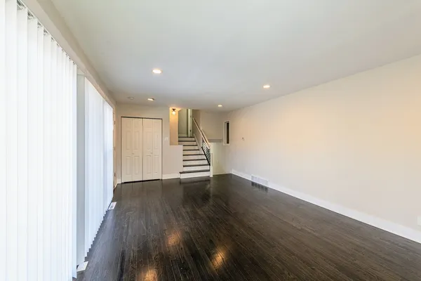 a view of an empty room with wooden floor