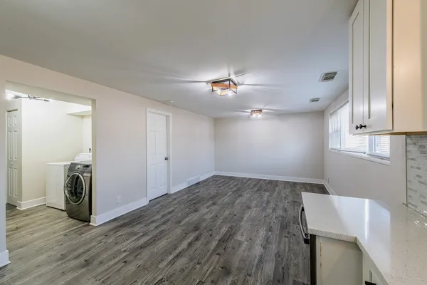 a view of empty room with wooden floor