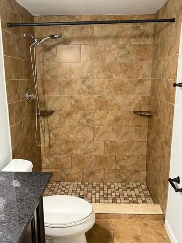 a bathroom with a toilet and a shower
