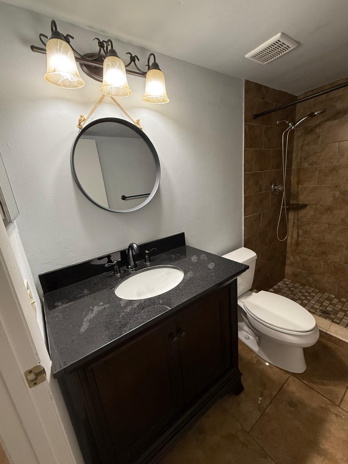 2335 Southwest 22nd Avenue, Unit 1030 Delray Beach, FL 33445 - Photo 30 of 41 a bathroom with a granite countertop toilet sink and mirror