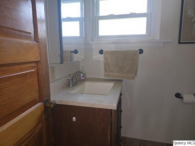 210 Main Street Carthage, IL 62321 - Photo 14 of 36 a bathroom with a granite countertop sink toilet and a mirror