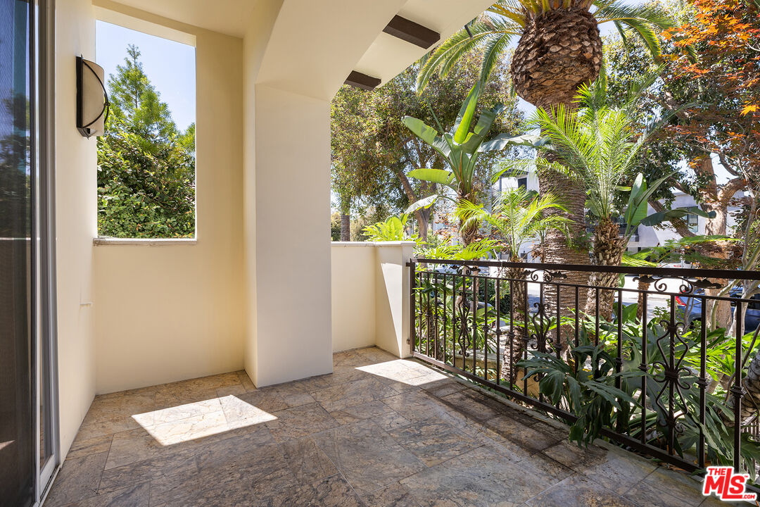 632 North Kings Road, Unit 102 West Hollywood, CA 90048 - Photo 10 of 13 a balcony with trees in front of it