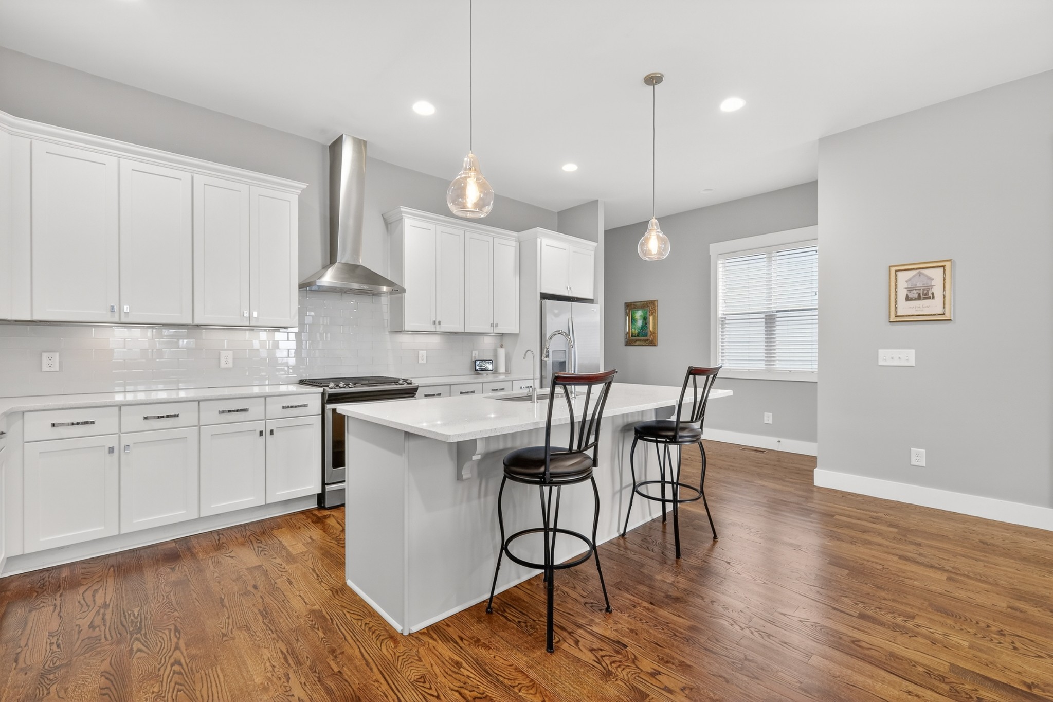 5812 Morrow Road, Unit A Nashville, TN 37209 - Photo 13 of 34 a kitchen with a dining table chairs wooden floors and white cabinets