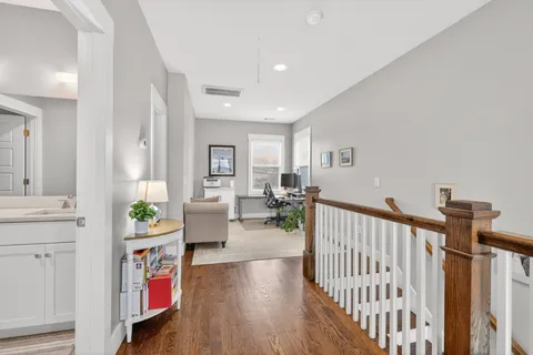 a view of a hallway with dining room and wooden floor