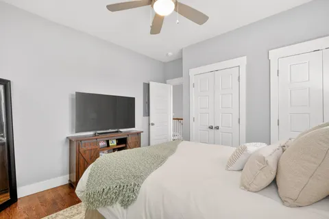 a bedroom with a bed and a flat tv screen on dresser