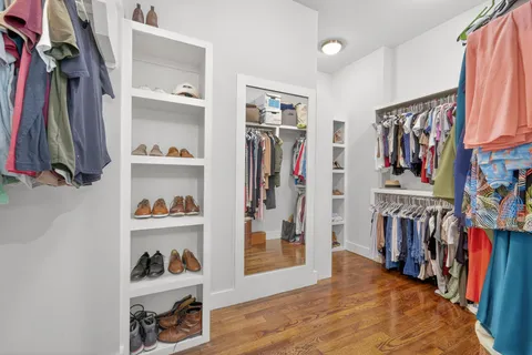 a view of walk in closet with clothes and shoes