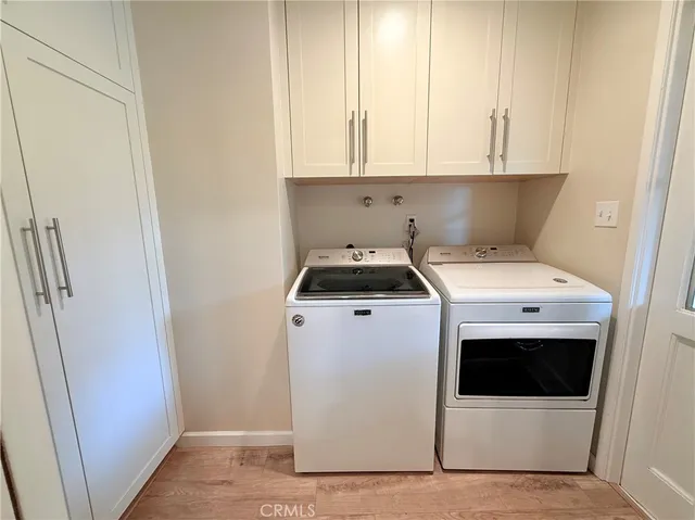 an empty room with windows fireplace and wooden floor