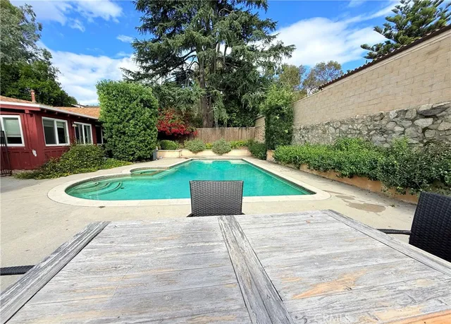 a view of backyard with seating space and trees in the background