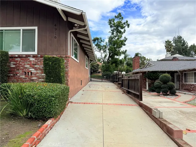a view of house with yard and potted plants