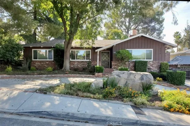 a front view of house with yard and trees around