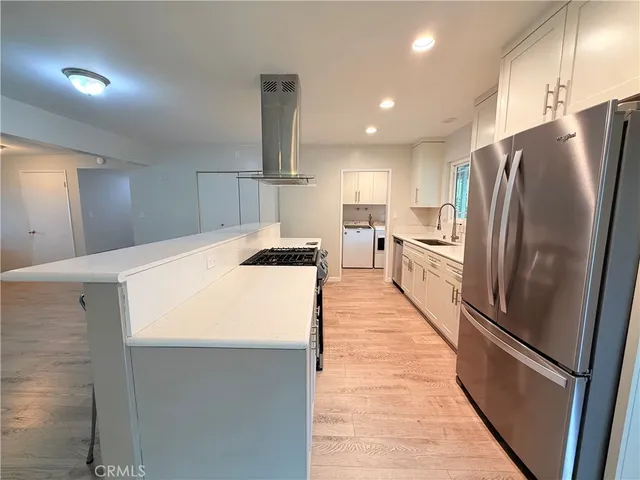 a kitchen with stainless steel appliances a refrigerator sink and stove