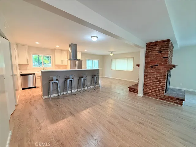 a kitchen with kitchen island a counter top space a sink a stove and a refrigerator