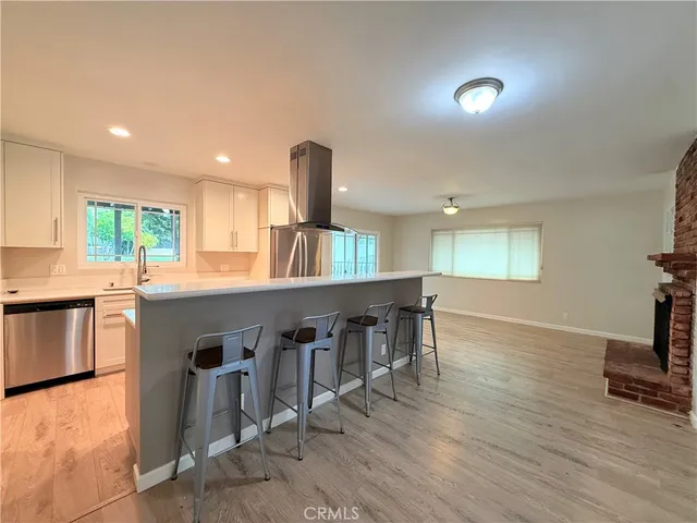 a kitchen with a dining table chairs and view living room