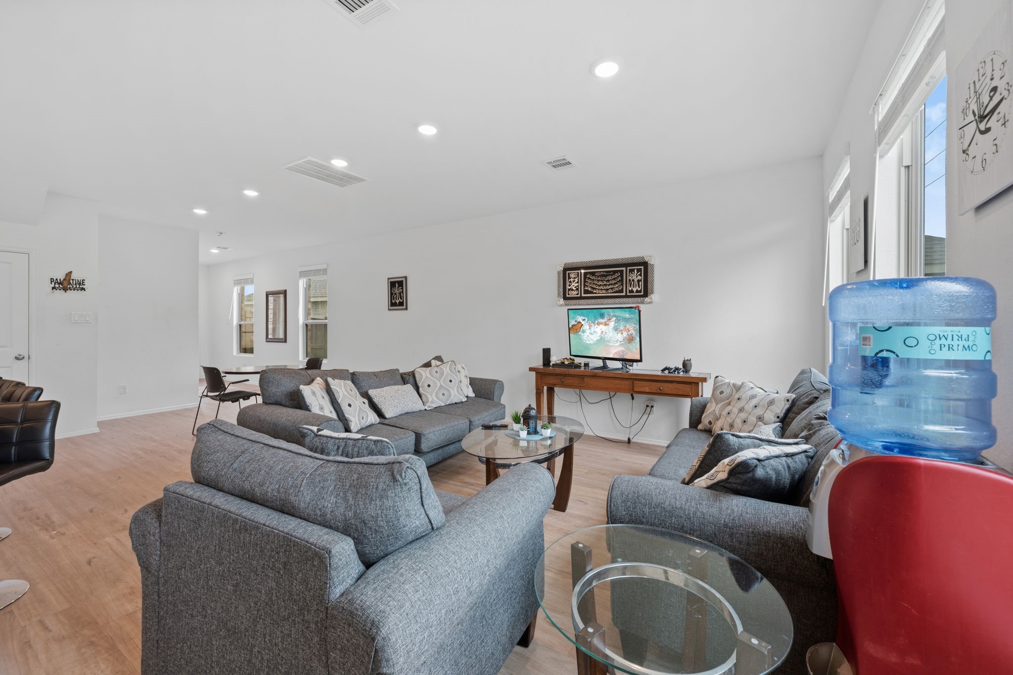 3043 Marble Rise Trail Porter, TX 77365 - Photo 13 of 27 Spacious living area with modern gray sofas, abundant natural light, and a sleek wooden floor, perfect for relaxation and entertainment.
