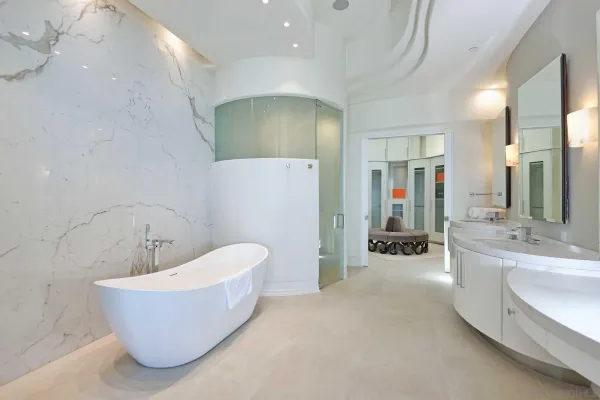 a bathroom with a tub a sink and mirror