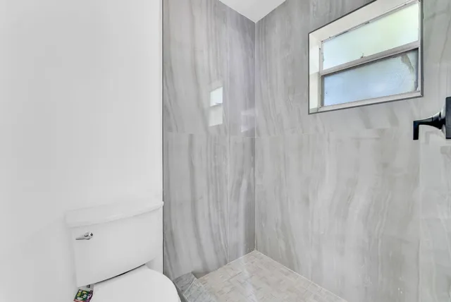 a bathroom with a toilet and a shower curtain