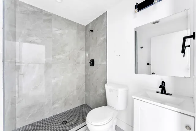 a bathroom with a sink a toilet and shower