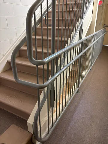 a view of staircase with railing and white walls