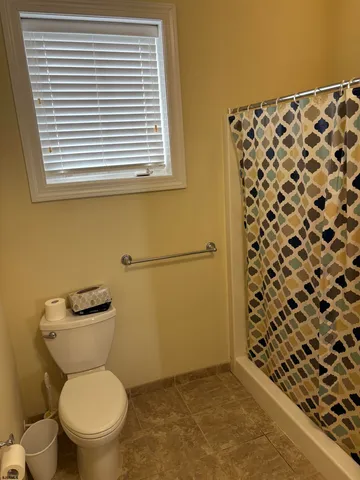 a bathroom with a toilet and a shower curtain