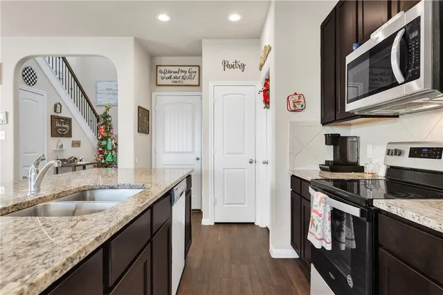a kitchen with stainless steel appliances granite countertop a sink stove and refrigerator
