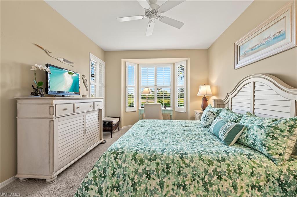 26901 Clarkston Drive, Unit 106 Bonita Springs, FL 34135 - Photo 20 of 24 a bedroom with a bed and a flat tv screen on dresser