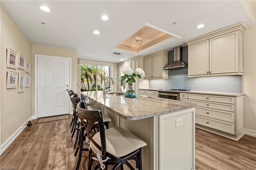 26901 Clarkston Drive, Unit 106 Bonita Springs, FL 34135 - Photo 3 of 24 a kitchen with stainless steel appliances granite countertop a stove a refrigerator a microwave oven with white cabinets and wooden floor
