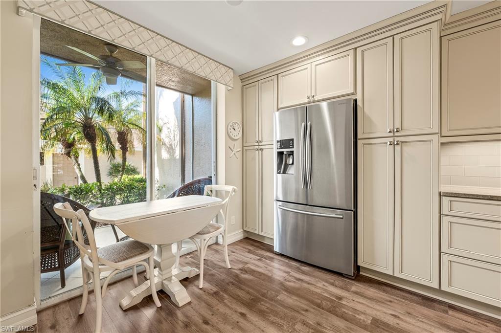 26901 Clarkston Drive, Unit 106 Bonita Springs, FL 34135 - Photo 4 of 24 a kitchen with stainless steel appliances granite countertop a refrigerator a microwave and a dining table