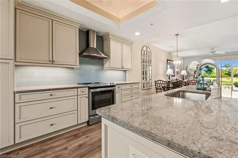 a kitchen with stainless steel appliances granite countertop a sink a stove and a refrigerator