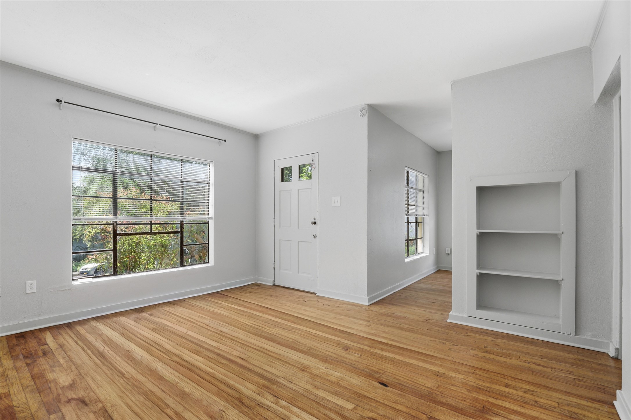 3901 Wrightwood Road, Unit A Austin, TX 78722 - Photo 3 of 11 Spacious room featuring wood-finish flooring, built-in shelving, and an abundance of natural light.
