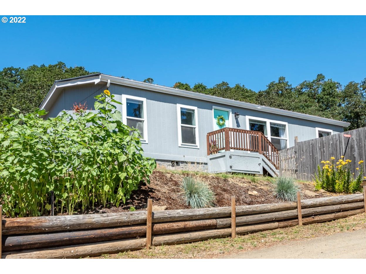 a view of a house with a small yard and wooden fence