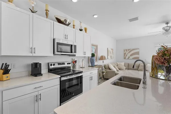 a kitchen with white cabinets and chairs