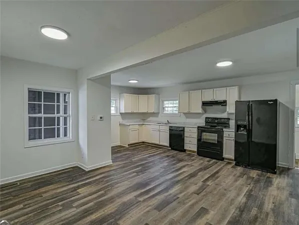 a large kitchen with a refrigerator and a stove top oven