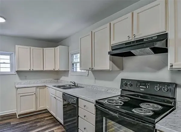a kitchen with granite countertop stainless steel appliances and white cabinets