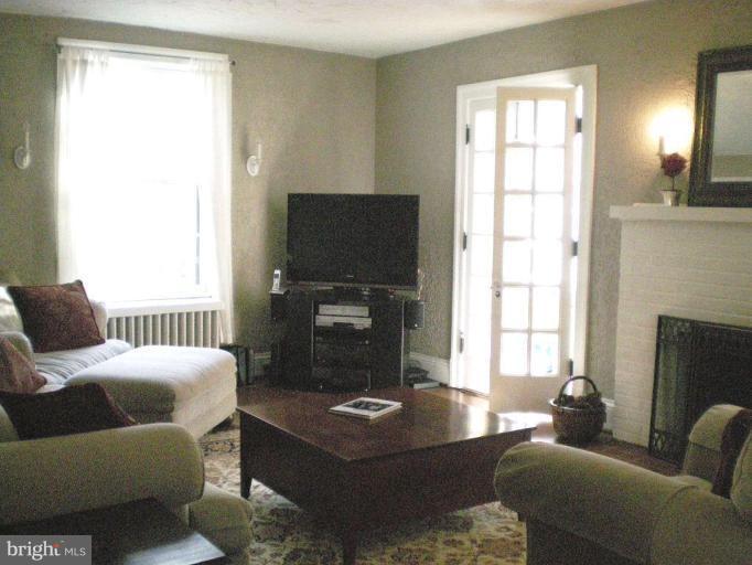1503 Frederick Road Catonsville, MD 21228 - Photo 11 of 23 a living room with furniture a fireplace and a flat screen tv